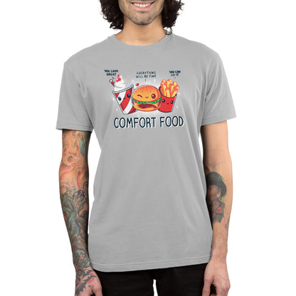 Premium Cotton T-shirt - Person wearing a light gray, unisex apparelmade from super soft ringspun cotton. The apparel features cartoon images of fries, a burger, and a drink above the text "Comfort Food." The individual has tattoos on their arms and is smiling. This "Comfort Food" apparel is by monsterdigital.