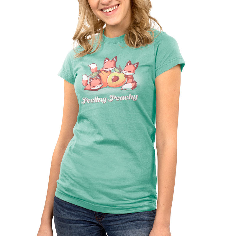 A woman wearing a green Feeling Peachy colored t-shirt with foxes on it. (Brand: TeeTurtle)