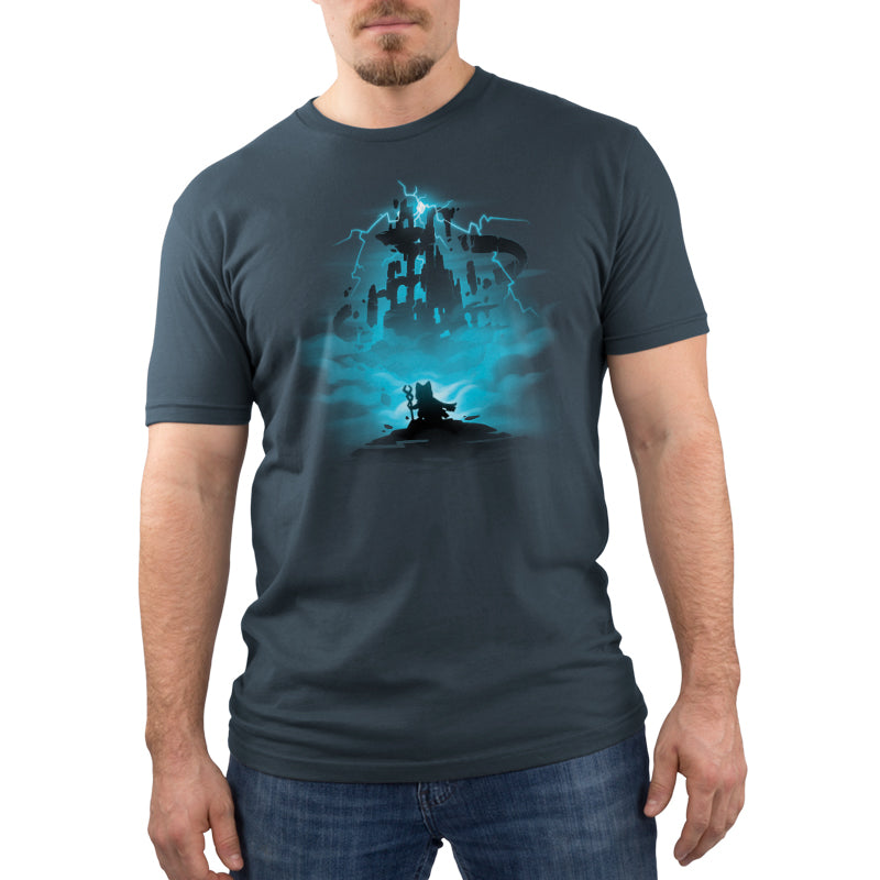 A man wearing a blue cotton Floating Ruins t-shirt by TeeTurtle, with a castle in the background, ready for an adventure.