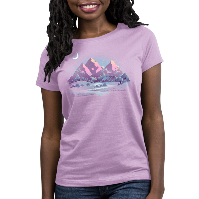 A woman in a Lavender Peaks t-shirt stands comfortably with mountains in the background. (Brand: TeeTurtle)