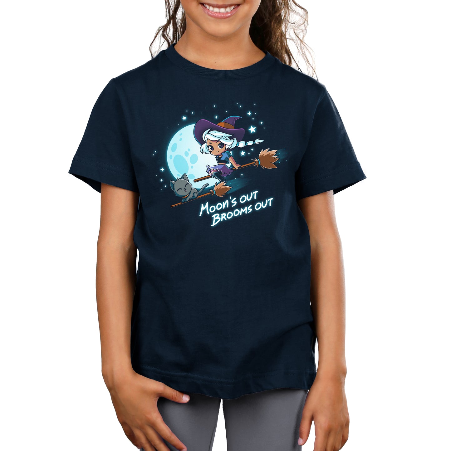 A girl wearing a Moon’s Out Brooms Out t-shirt by TeeTurtle with a witch on it.