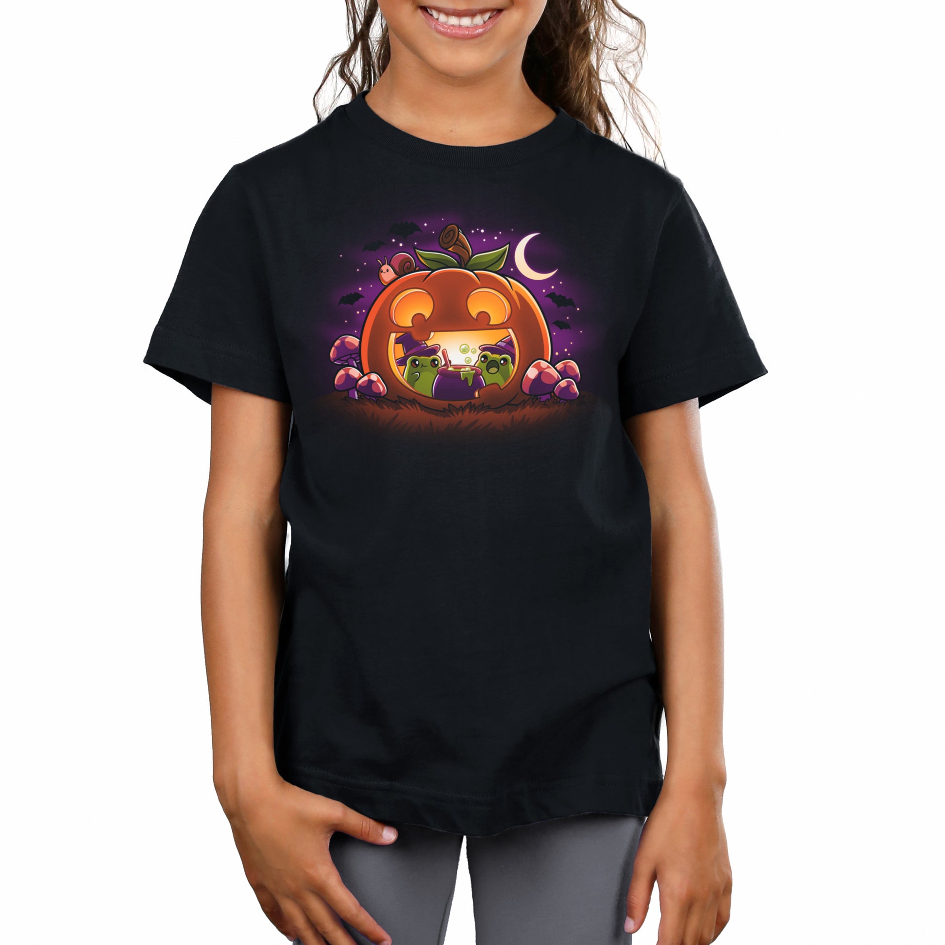 A girl wearing a comfortable TeeTurtle Halloween t-shirt with an image of Pumpkin Frog Witches.