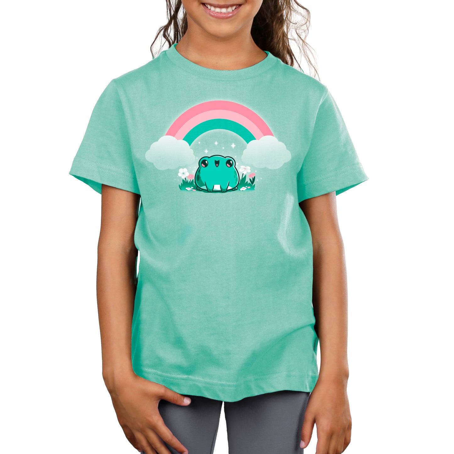 A girl wearing a green t-shirt with TeeTurtle's Rainbow Ribbits in front of a saltwater aquarium.
