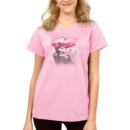 A woman wearing a pink Sakura Tree T-shirt from TeeTurtle with a flower on it.