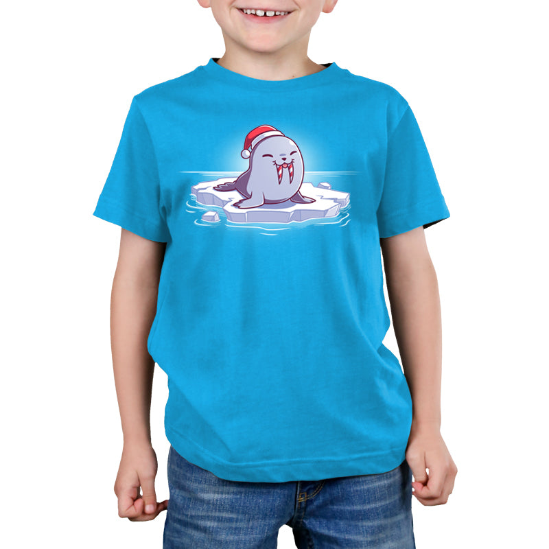 A young boy with a Sweet Tooth wearing a blue t-shirt with a santa hat.