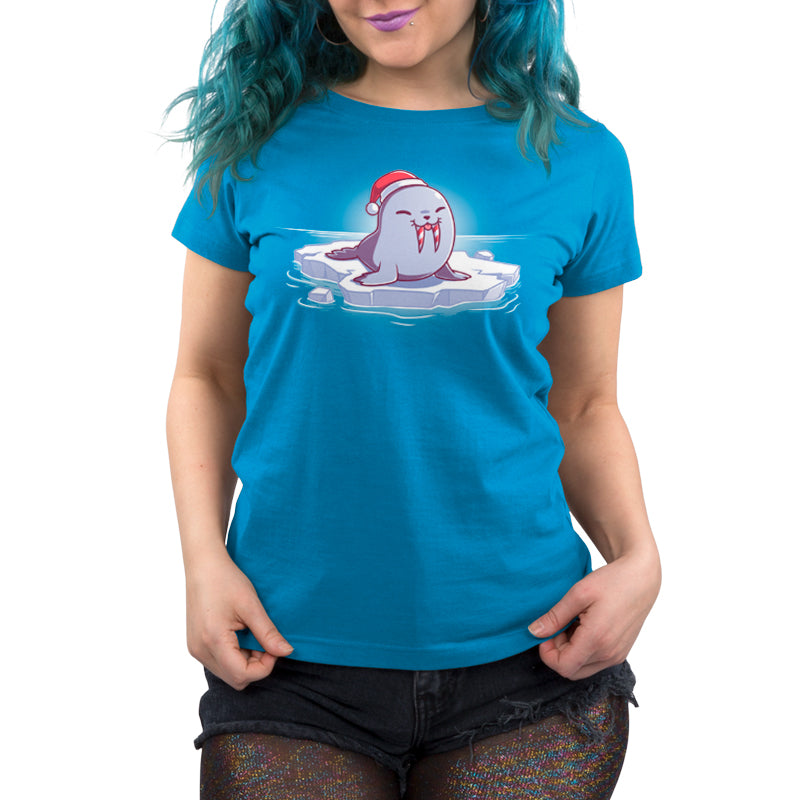 A woman wearing a blue TeeTurtle T-shirt with a Santa hat on it has a Sweet Tooth for holiday candy.