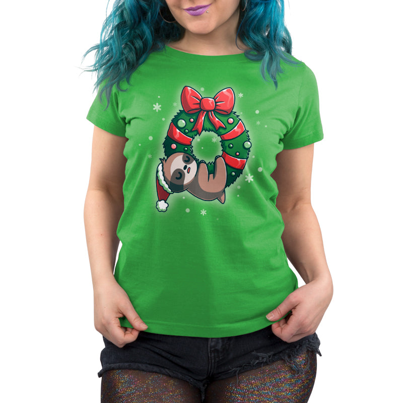 A woman wearing a green T-shirt with a sloth on it from TeeTurtle called "We Wish You a Lazy Christmas.