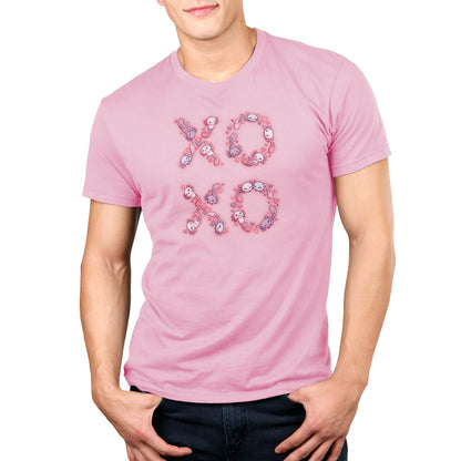 A man wearing a pink TeeTurtle Ringspun Cotton T-shirt with the word XOXO on it.