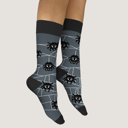 A pair of Spooky Spider Socks by TeeTurtle with webs on them.
