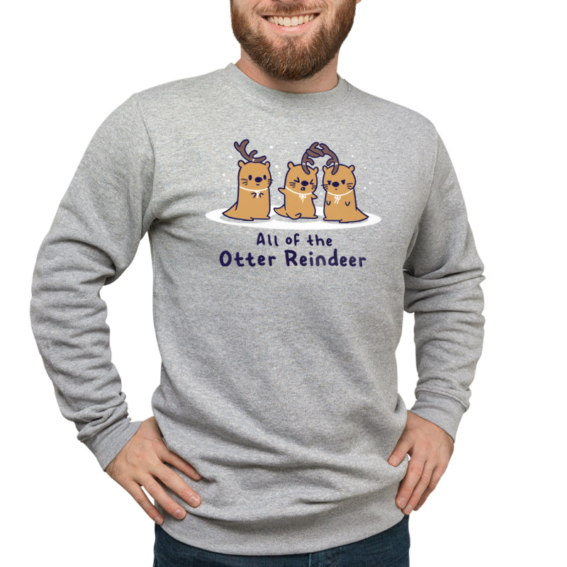 A man wearing a TeeTurtle sweatshirt that says "All Of The Otter Reindeer" during the holiday season.