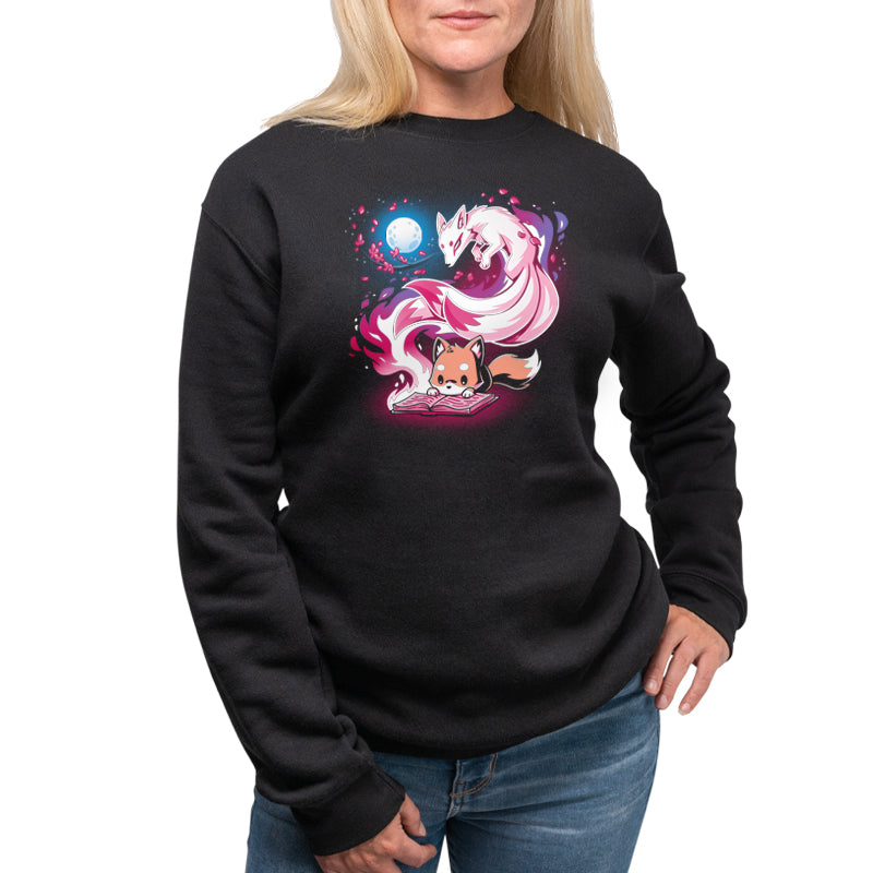 A woman wearing a black Tale of Tails sweatshirt with an image of a unicorn by TeeTurtle.