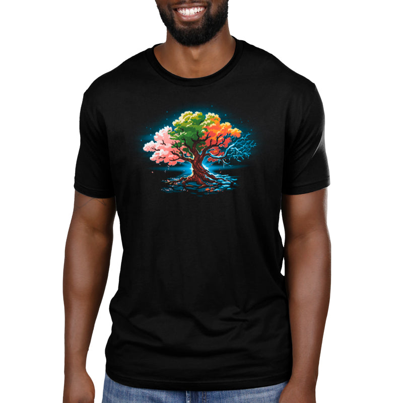 A man wearing a black t-shirt with a TeeTurtle Seasonal Tree on it representing the change of seasons.