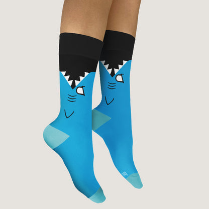 A woman wearing a pair of comfortable TeeTurtle Shark Bite Socks.