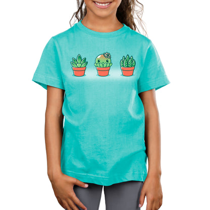 A girl wearing a turquoise TeeTurtle Succulent Surprise t-shirt with cactus plants on it.