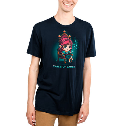 A young man wearing a navy blue Tabletop Gamer t-shirt with a cartoon character on it by TeeTurtle.