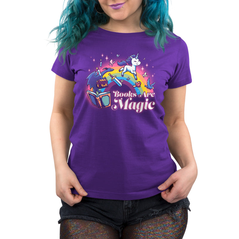 A woman wearing a purple t-shirt featuring the Books Are Magic (Unicorn) from TeeTurtle.