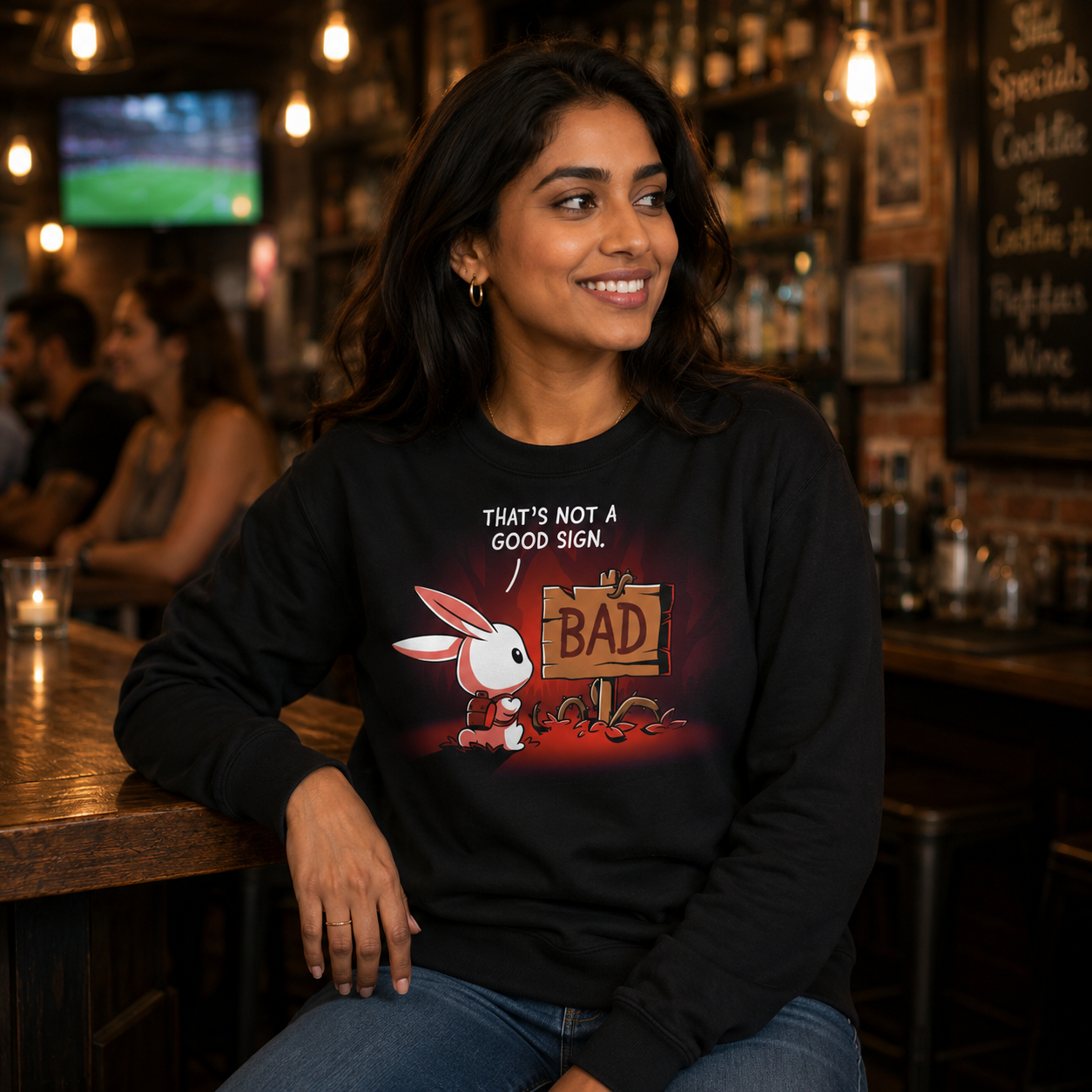 Crew Neck Sweatshirt_TeeTurtle That's Not a Good Sign black design featuring an adventurous bunny looking at a wooden sign with the word "bad" on it.
