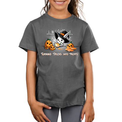 A girl wearing a Turning Tricks Into Treats t-shirt from TeeTurtle with a pumpkin.