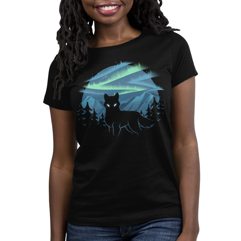 A person wearing a super soft ringspun cotton black t-shirt featuring an illustration of a glowing-eyed wolf, trees, colorful northern lights, and mountains in the background by monsterdigital called Wild Aurora.