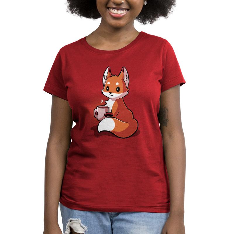 A woman wearing a garnet red t-shirt with a TeeTurtle Coffee Fox holding a cup.