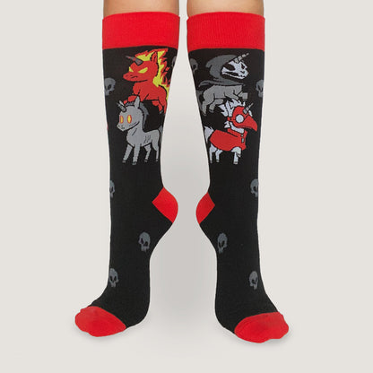 A woman wearing a pair of TeeTurtle Four Unicorns of the Apocalypse Socks with horses on them.