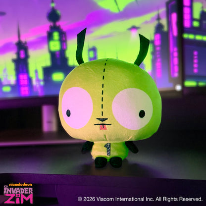 GIR Cloudheads plush sitting on a desk with a colorful green and purple cityscape in the background.
