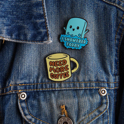 A denim jacket adorned with TeeTurtle's I Showered Today Pin, showcasing personal victories.