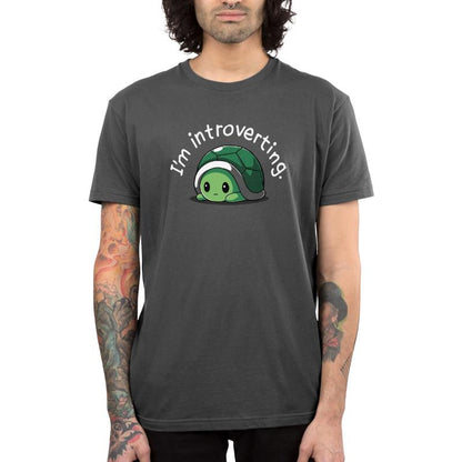 A man wearing a charcoal gray t-shirt that says "I'm Introverting" from TeeTurtle.