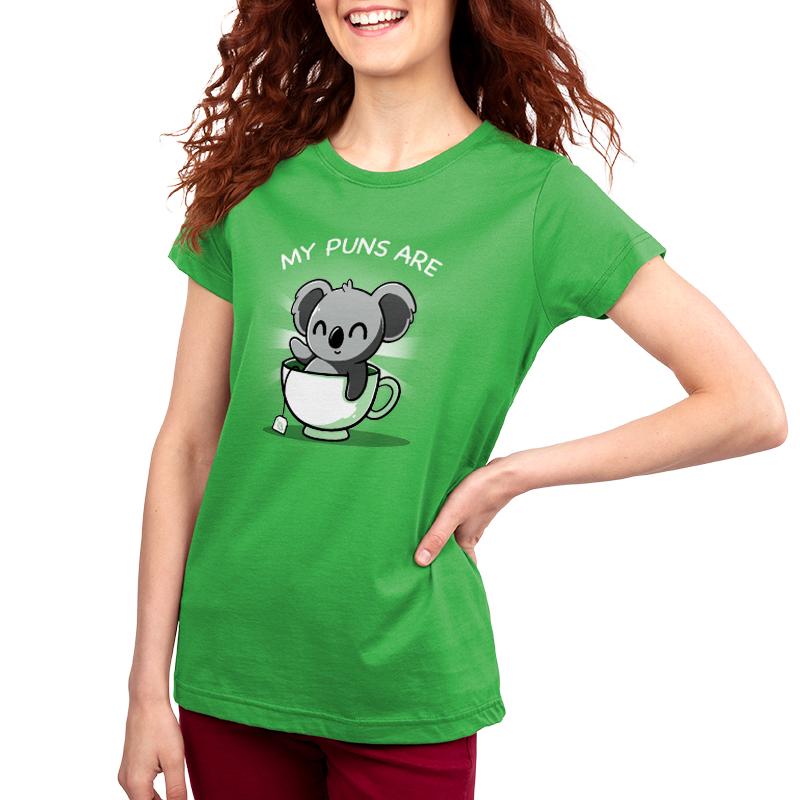 A woman wearing a TeeTurtle original green t-shirt with the Koala Tea Puns brand's logo of a koala in a cup of tea.