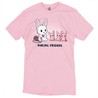 Premium Cotton T-shirt_Teeturtle Making Friends Pink t-shirt Featuring a white-furred bunny knitting bunny friends out of yarn.