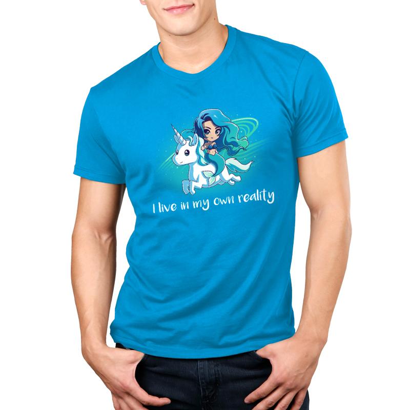 Man wearing a cobalt blue t-shirt with an illustrated woman riding a unicorn and the text "I live in my own reality," which is the My Reality shirt by monsterdigital.