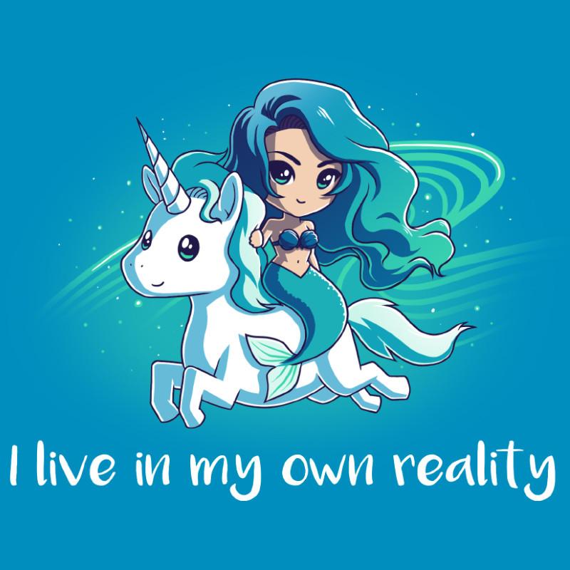 A cartoon mermaid with blue-green hair rides a white unicorn with a cobalt blue mane and tail. The text at the bottom reads, "I live in my own reality." The background is blue with starry accents. This is the "My Reality" by monsterdigital.