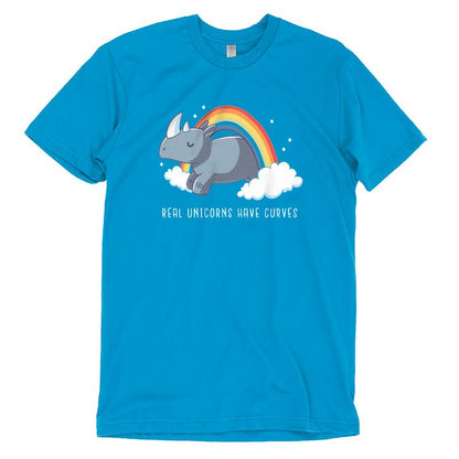 Cobalt blue t-shirt featuring a cartoon rhino with a horn, lying on clouds with a rainbow above it and the text, "REAL UNICORNS HAVE CURVES." Made from super soft ringspun cotton for extra comfort. Product Name: Real Unicorns Have Curves, Brand Name: monsterdigital.