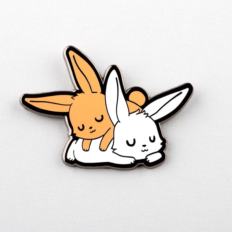 Two Sleepy Bunnies Pins by TeeTurtle on a white surface.