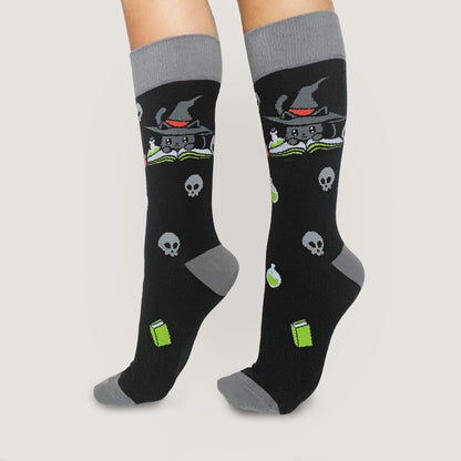 A woman wearing comfortable TeeTurtle Spellbound Socks with skulls and witches on them.