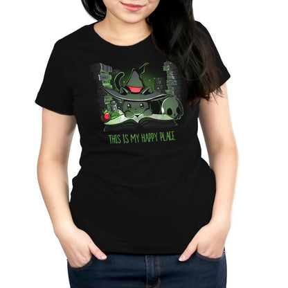 Person wearing a super soft ringspun cotton, unisex tee featuring a cartoon cat with a witch hat, potion, skull, and apple, with the text "This is my happy place," called "Spellbound" by monsterdigital.