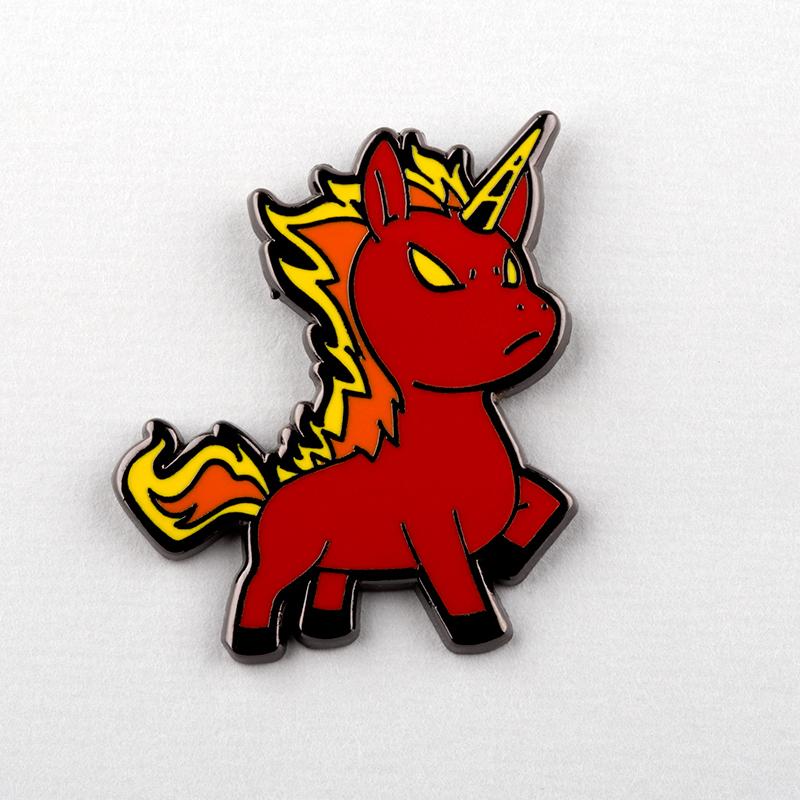 A small TeeTurtle enamel pin with a red Unicorn of War on it.