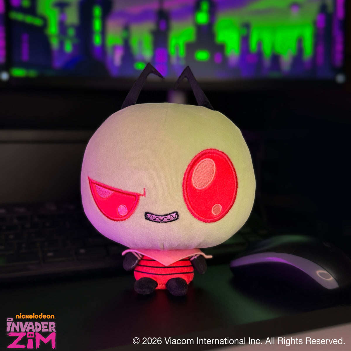 Zim Cloudheads plush sitting on a desk with a colorful green and purple cityscape in the background.